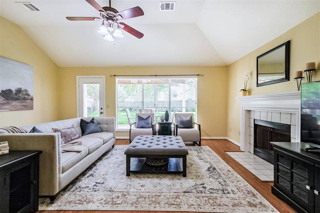 The living room features large picture windows, high ceilings, fireplace, and a ceiling fan.