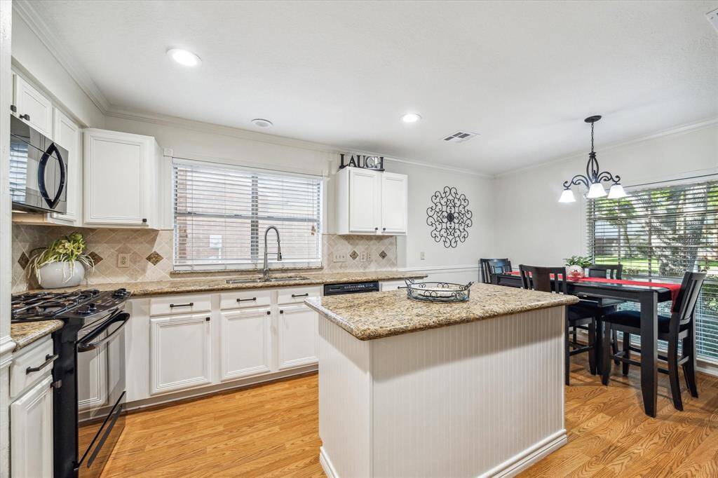 The kitchen and breakfast room are to the right of the entryway . Features include gas range and windowover the deep sink.