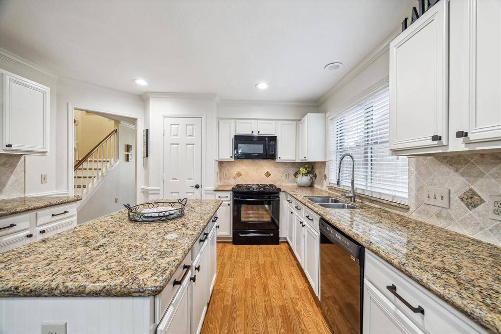 Light and bright cabinets with new hardware, granite counters and island prep space!Functional and beautiful kitchen.