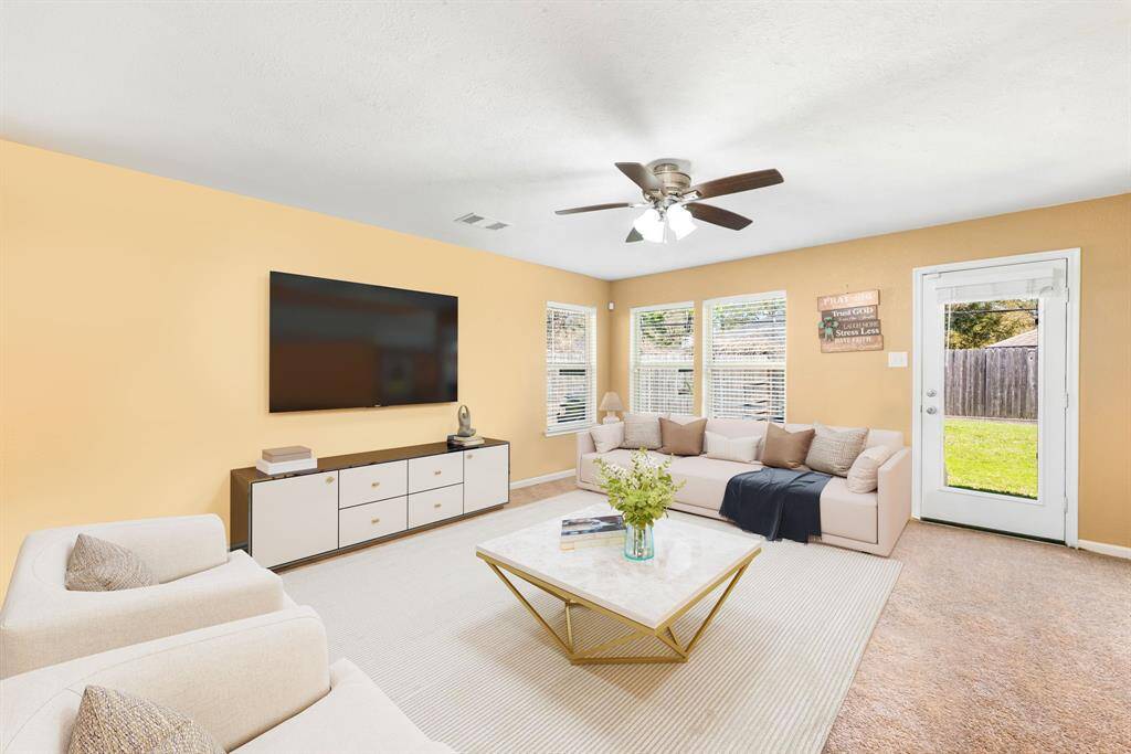 This light and bright spacious living room is the perfect layout for entertaining or just relaxing. Whether it's simply a night in or entertaining family and friends, this home has ample open space for everyone to enjoy! Featuring dark stained ceiling fan, plush carpet flooring, large windows with blinds, high ceilings, with wonderful access to your gorgeous kitchen and backyard.