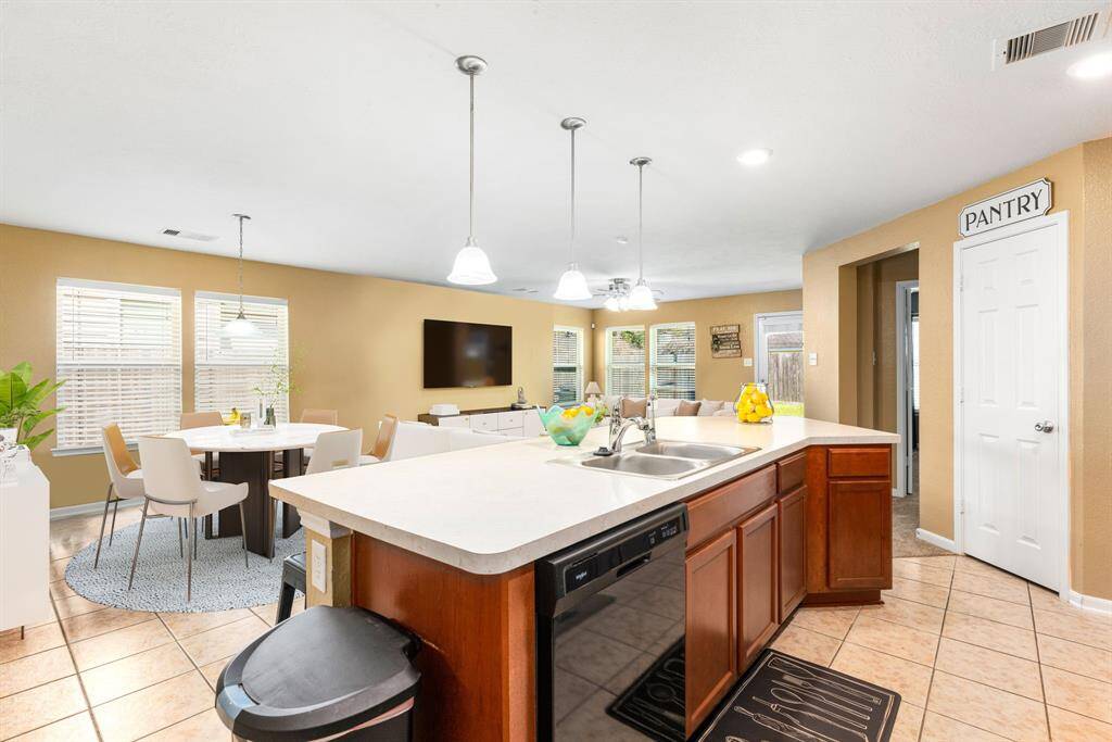 The open concept living room and kitchen makes for a great way to keep the party going and never miss a beat! Gather the family together in good conversation while preparing a fabulous meal in this breathtaking kitchen! Featuring large high ceilings, dark stained wood cabinets, modern tile backsplash, recessed lighting with beautiful pendant lighting over the seating area, kitchen island with ample counter space!