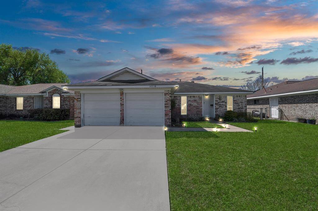 Charming home with a two-car garage and a welcoming manicured front lawn and long driveway. Perfect for a cozy and inviting living space.