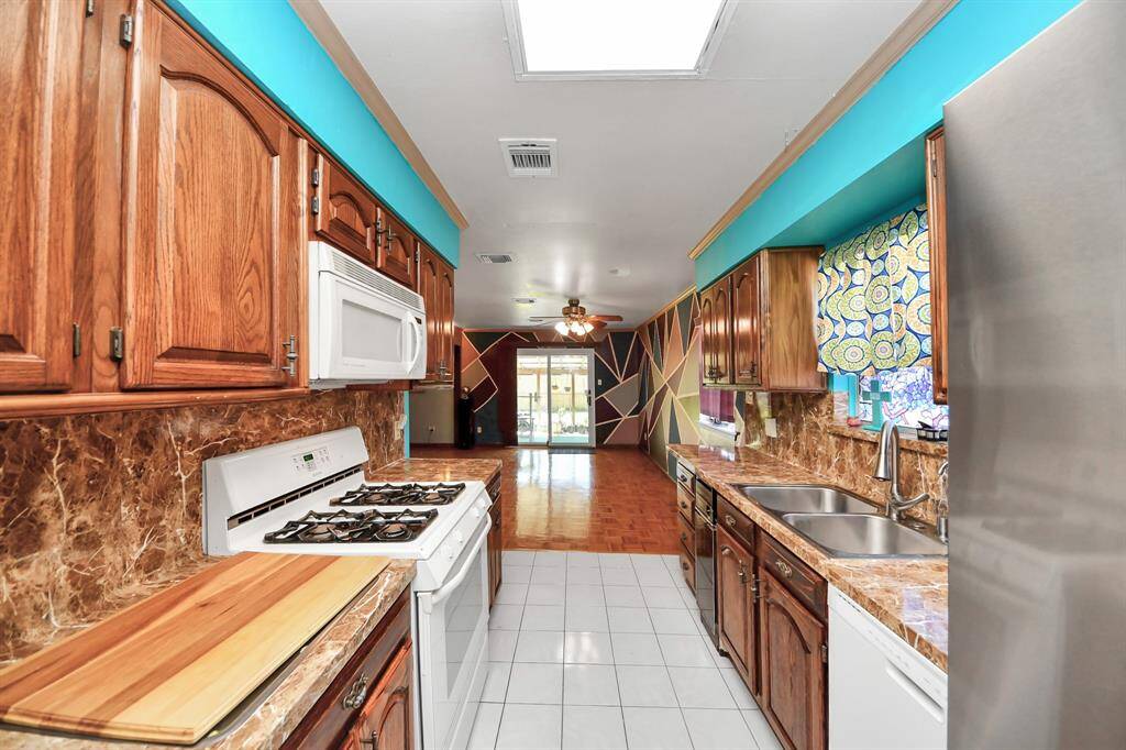 Efficient kitchen equipped with gas stove, dish washer, microwave and new stainless steel Samsung refrigerator.