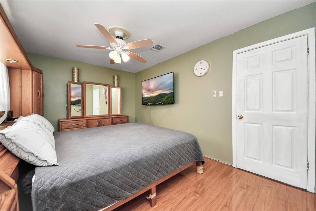 The color scheme and beautiful flooring add warmth and functionality to this primary bedroom.