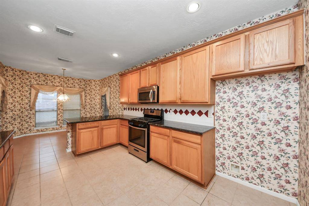 Spacious kitchen with warm wood cabinetry,