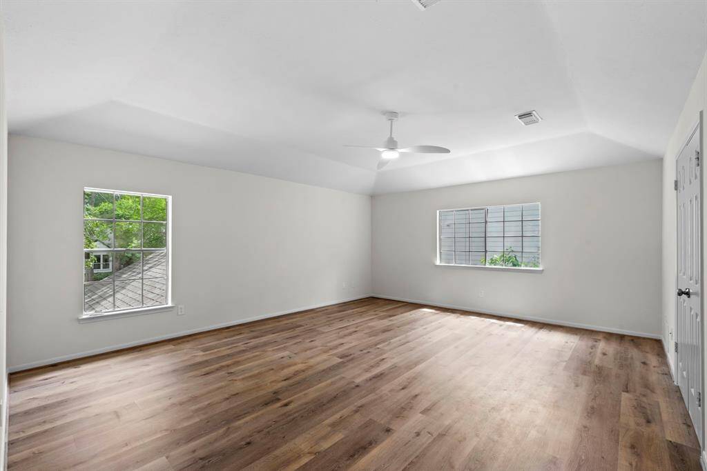 The view from the entry door of the primary bedroom upstairs. This shows the two large windows that allow ample natural light into the room.