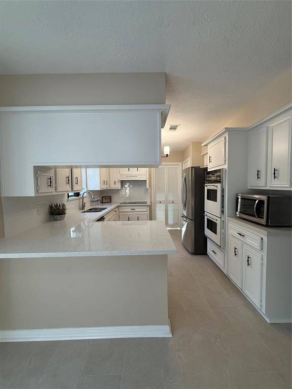 The kitchen, includes the refrigerator and the microwave.