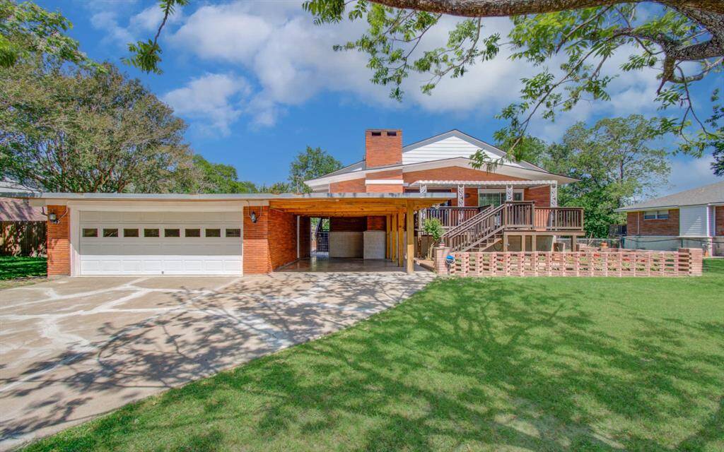 This captivating home sits on a raised elevation and boasts a spacious front yard adorned with mature trees. An oversized two-car garage, additional carport, and expansive driveway offer ample parking options. The brick exterior and welcoming front porch enhance its curb appeal, making it an appealing choice for potential buyers.