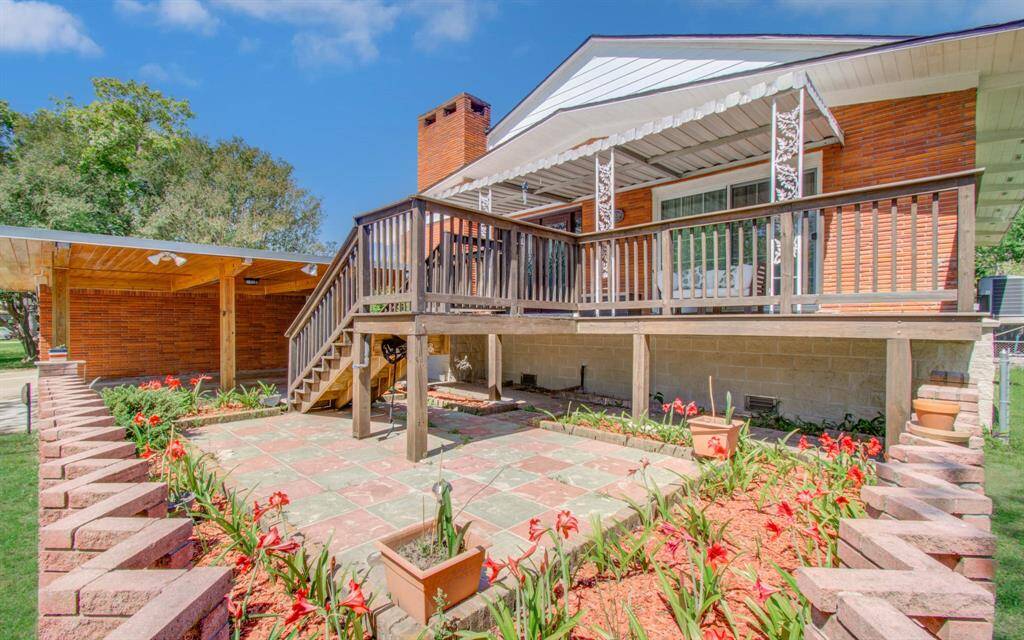 The elevated deck is one of the highlights of this property, featuring decorative railings, generous space for relaxing, and a covered area perfect for enjoying the outdoors in any weather. It’s an ideal spot to take in views of the neighborhood and soak in Jersey Village’s welcoming sense of neighborliness. Just below, the landscaped patio is framed by a brick border and vibrant flower beds, with ample potential to cultivate a lush, garden-like retreat.