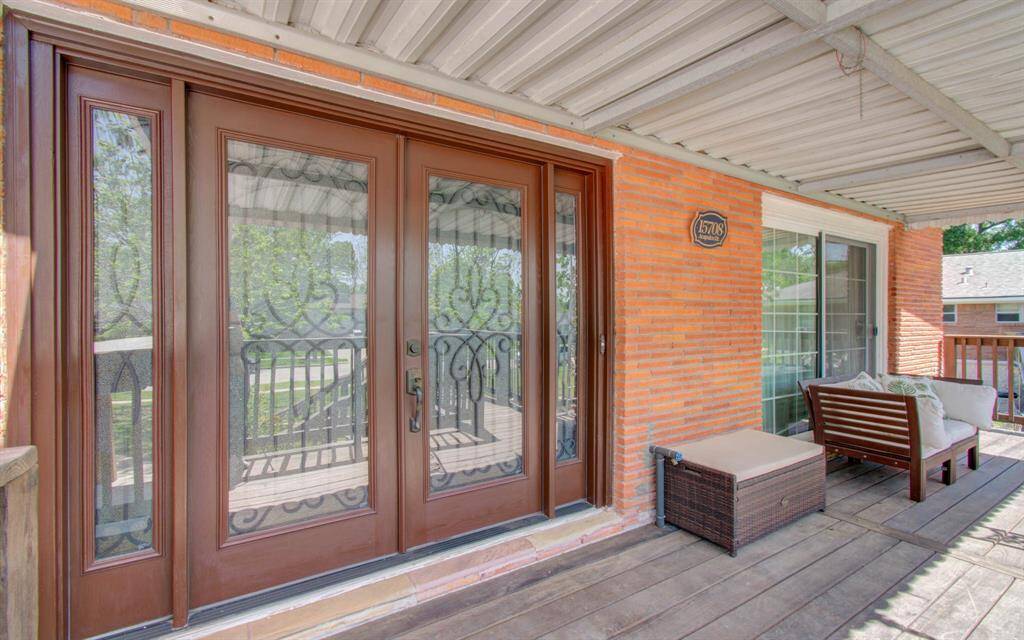 The eye-catching glass double doors serve as the focal point of this inviting porch, exuding a sense of grandeur and sophistication.