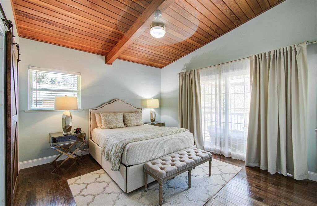 The primary bedroom offers a warm and tranquil retreat, featuring a wooden ceiling and matching floors that add natural charm and character. Large windows allow soft, natural light to pour in, enhancing the room’s airy and inviting feel. With its open layout and serene atmosphere, this space is the perfect blend of comfort and calm.