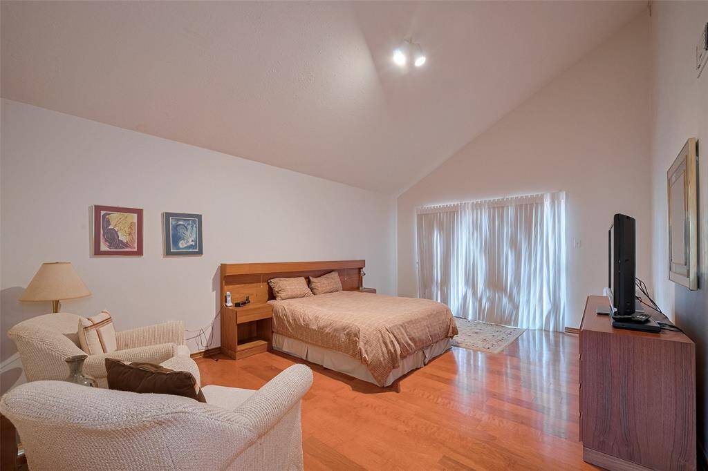 The Primary Bedroom offers a spacious layout with a soothing neutral interior, elegant high ceilings, andstunning wood flooring, creating a peaceful and refined retreat.