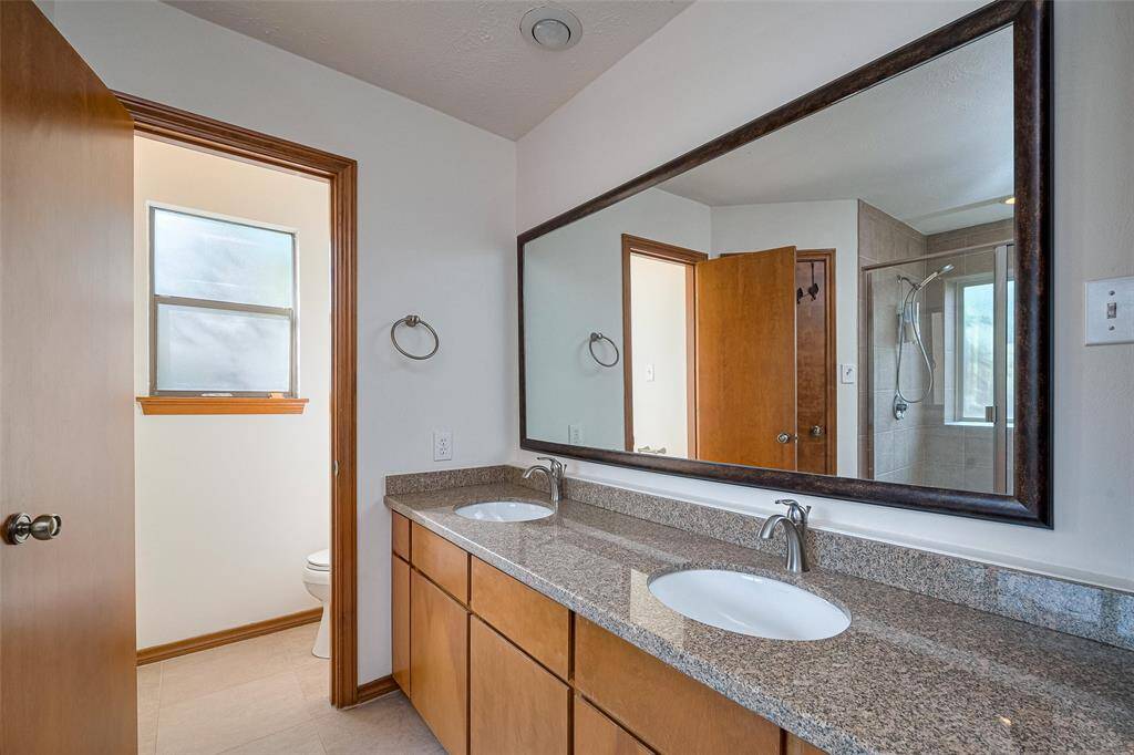 Double vanities with expansive counter space are a must-have for any primary bath, and this one delivers beautifully. It also features wall-to-wall mirrors and ample cabinet and drawer storage, combining style with everyday functionality.