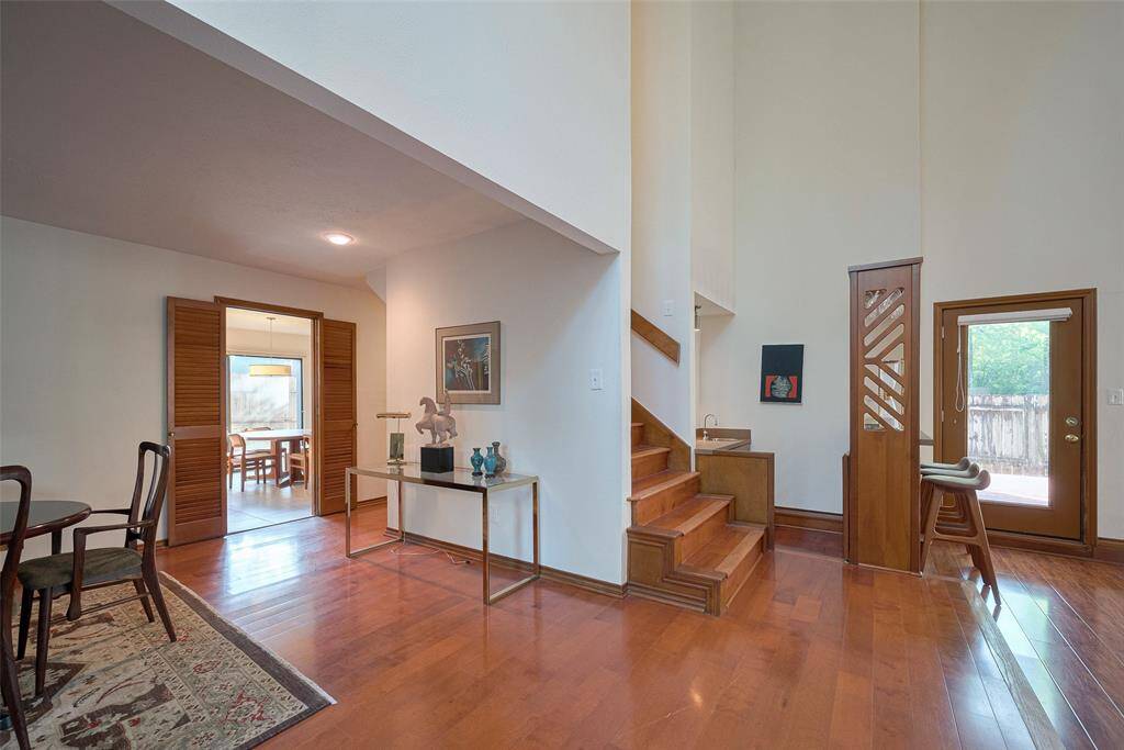 Picture yourself opening this door to greet guests, where gleaming wood floors, soaring ceilings, and abundant natural light create a warm and elegant welcome. This beautifully crafted entryway sets the stage for the home's timeless charm and refined atmosphere.