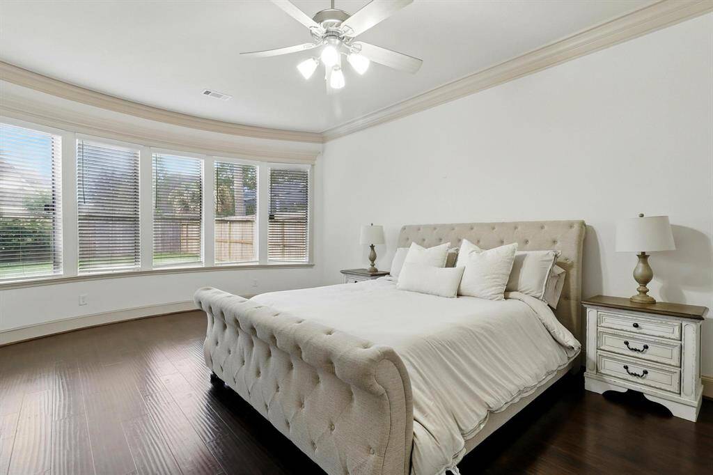 Sunlight spills generously into the rustic primary bedroom, likely through large windows that may offer views of nature