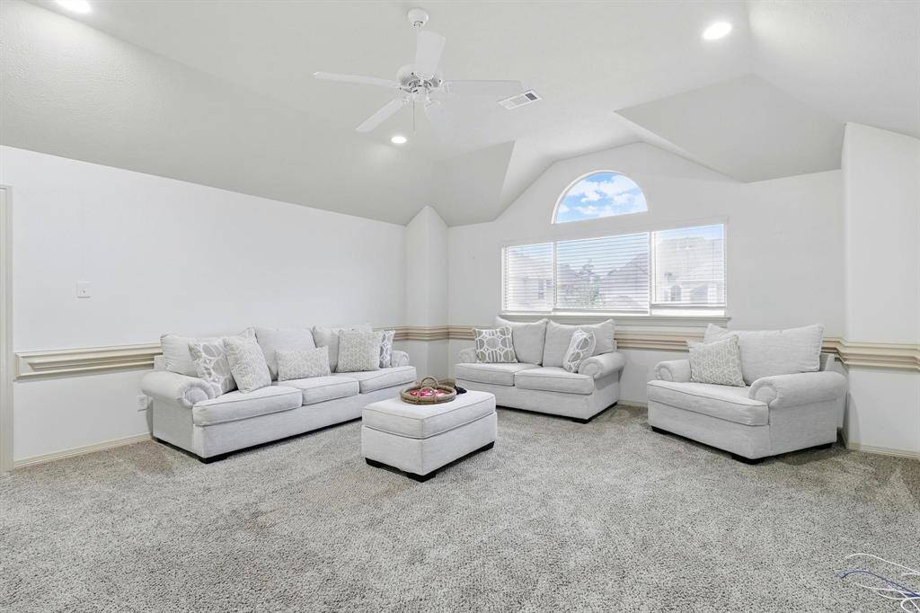 The upstairs family room exudes a sense of comfortable warmth and relaxation. Soft, inviting seating, likely a plush sectional sofa or a collection of oversized armchairs and a comfortable sofa, is arranged to encourage lounging and togetherness