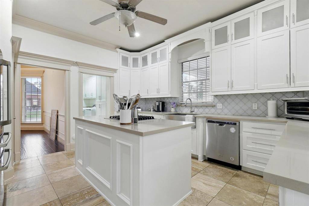 Kitchen is equipped with contemporary appliances and sleek countertops