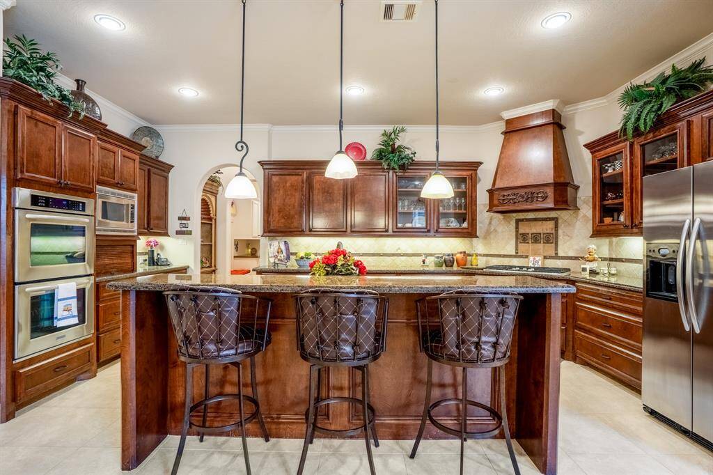 We already know everyone's favorite gathering spot is around the kitchen island, but this one is exceptional due to the addition of the breakfast bar and a direct view into the backyard oasis.