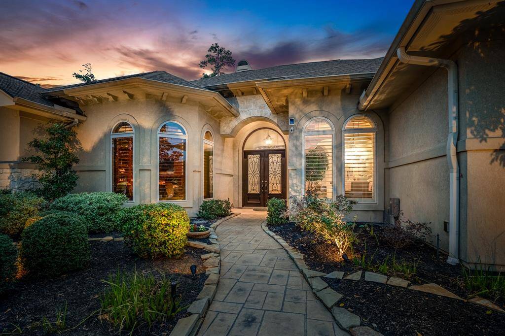 The stucco exterior showcases stone accents, arched windows, showcasing charming shutters, all set against a picturesque twilight sky. Best of all? Hooks for hanging Holiday lights are already pre-installed, so you can go ahead and check that off of your list now!