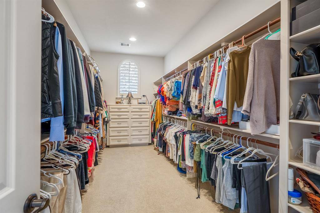 View of one of the two incredibly spacious primary closets with tall built-ins.