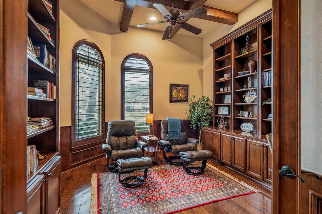 The office exudes a moody and masculine ambiance, characterized by rich wood paneling and floors that impart warmth and sophistication. The deep hues of the wood create an intimate atmosphere, ideal for focused work or contemplation. Complementing the wood tones, leather furnishings and strategic lighting enhance the room's depth and character, embodying a timeless and refined workspace.