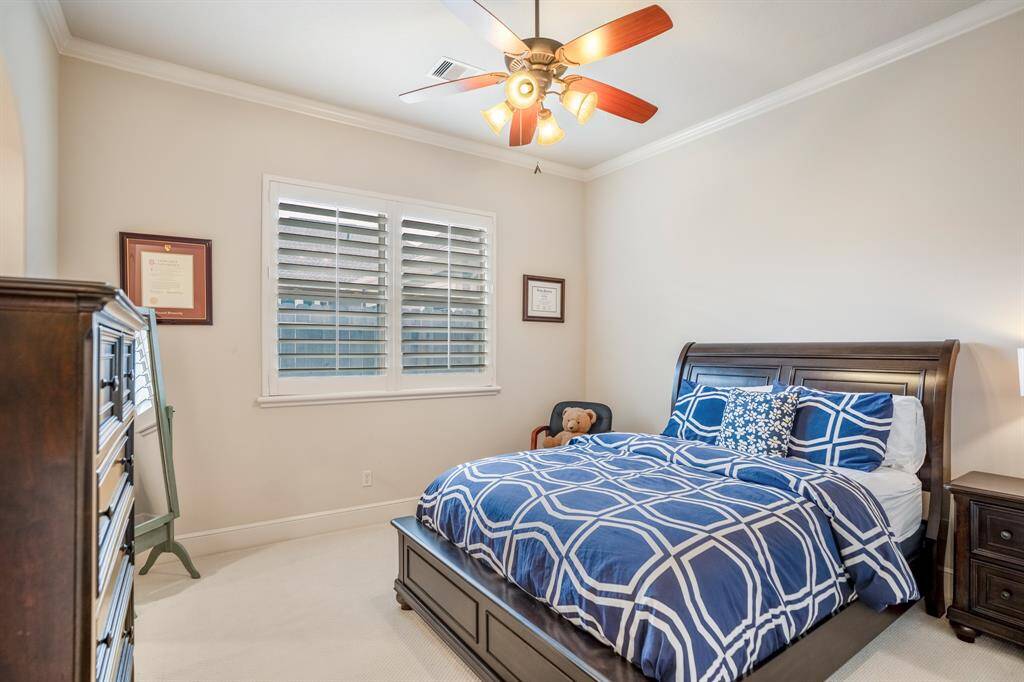 This cozy bedroom features plush carpet and generous closet space. Large windows provide abundant natural light, enhancing the room's airy feel.