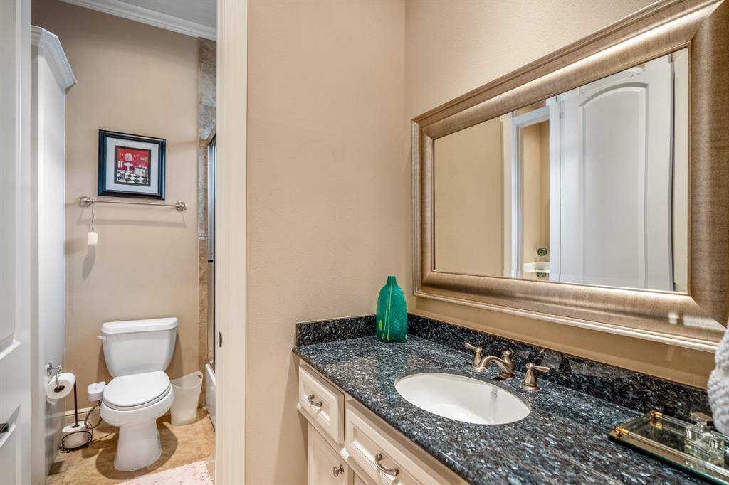 Shared between two bedrooms, this jack & jill bathroom includes separate sinks/vanity spaces, a glass-enclosed shower/tub combo, and thoughtful design ensuring both functionality and privacy for occupants.