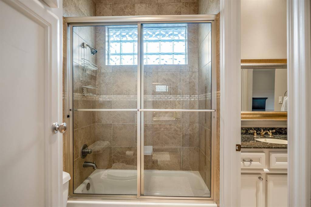 Alternate angle showing shared glass-enclosed shower.