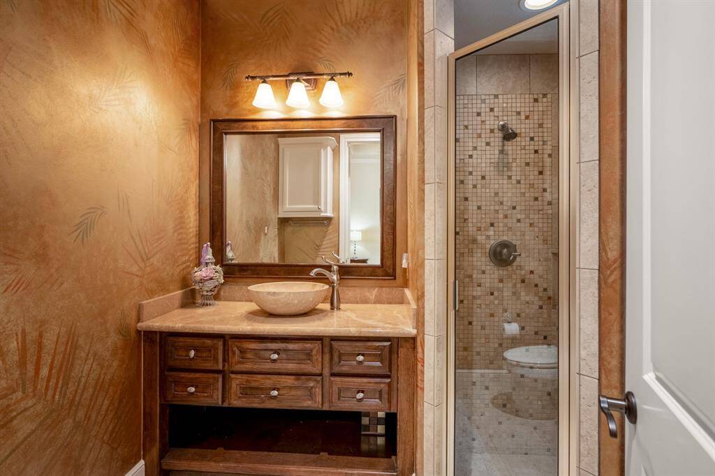 The private ensuite bathroom boasts elegant fixtures, a walk-in shower, and a sleek vanity with a vessel sink & ample storage. Its direct access to the backyard provides convenience and a seamless indoor-outdoor living experience. Perfect for guests!