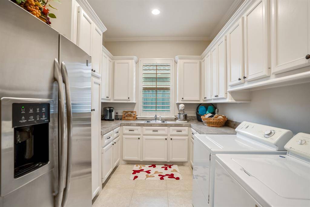 One of the largest utility rooms you've seen, it currently serves double duty as a butlers pantry as well. With close proximity to the kitchen, you can keep your extra essentials tucked away in here.