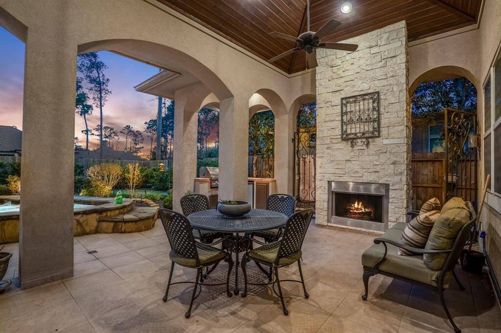 An expansive lanai houses a state-of-the-art outdoor kitchen, complete with a built-in grill, sink, fridge, and ample counter space as well as a floor-to-ceiling limestone surround gas fireplace. This area offers generous seating for both dining and lounging, making it ideal for hosting gatherings and enjoying meals al fresco.