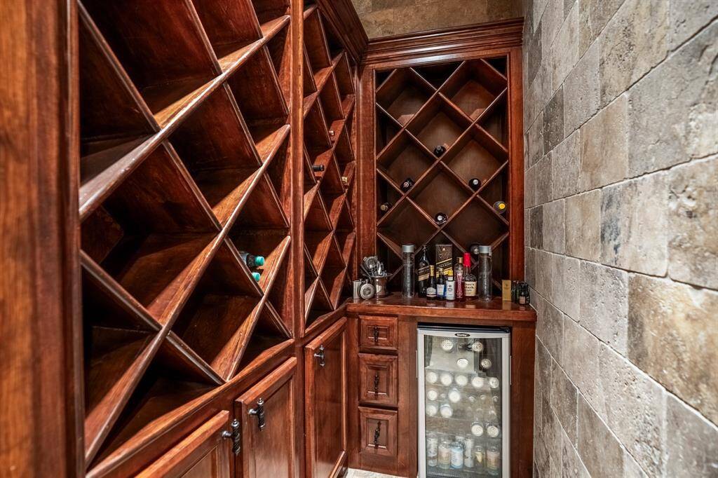 An entertainer's dream! Enjoy your favorite vintages, showcased in this cozy wine grotto with rich wooden racks for and a stone accent wall, complete with a beverage refrigerator.