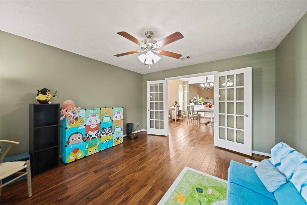 Office/library/study/flex room with hardwood flooring, bright lighting, and French door
