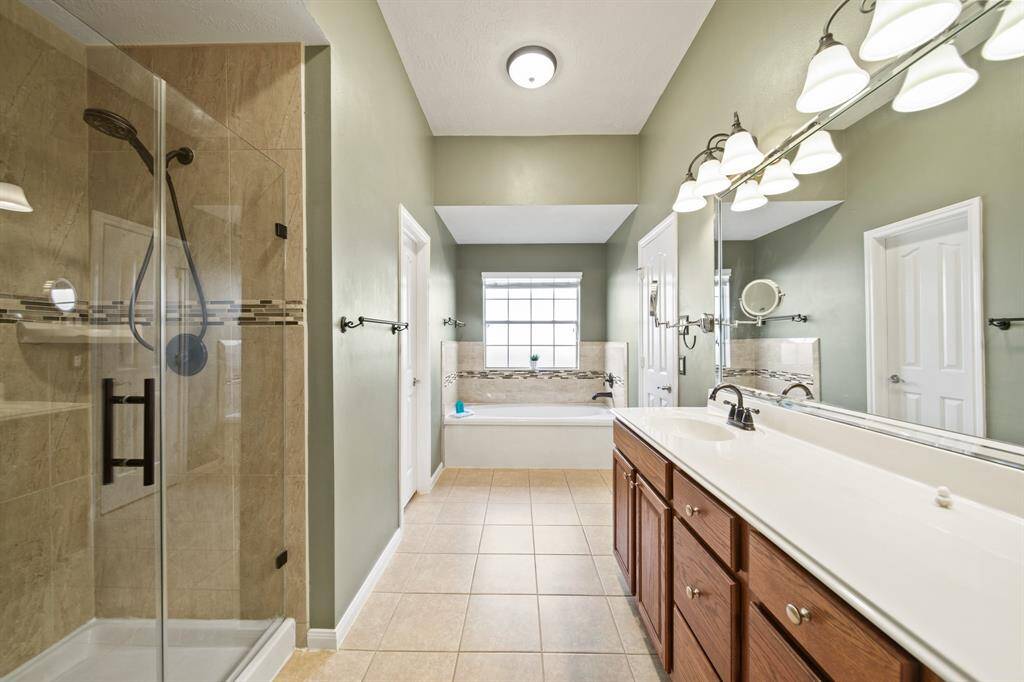 Spacious full bathroom with ample vanity space, shower/separate bath, and well-lit interior.