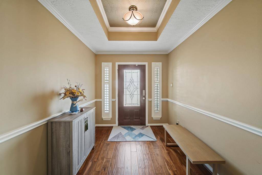Inviting entryway with warm hardwood floor and decorative lighting fixture creates a welcoming atmosphere.