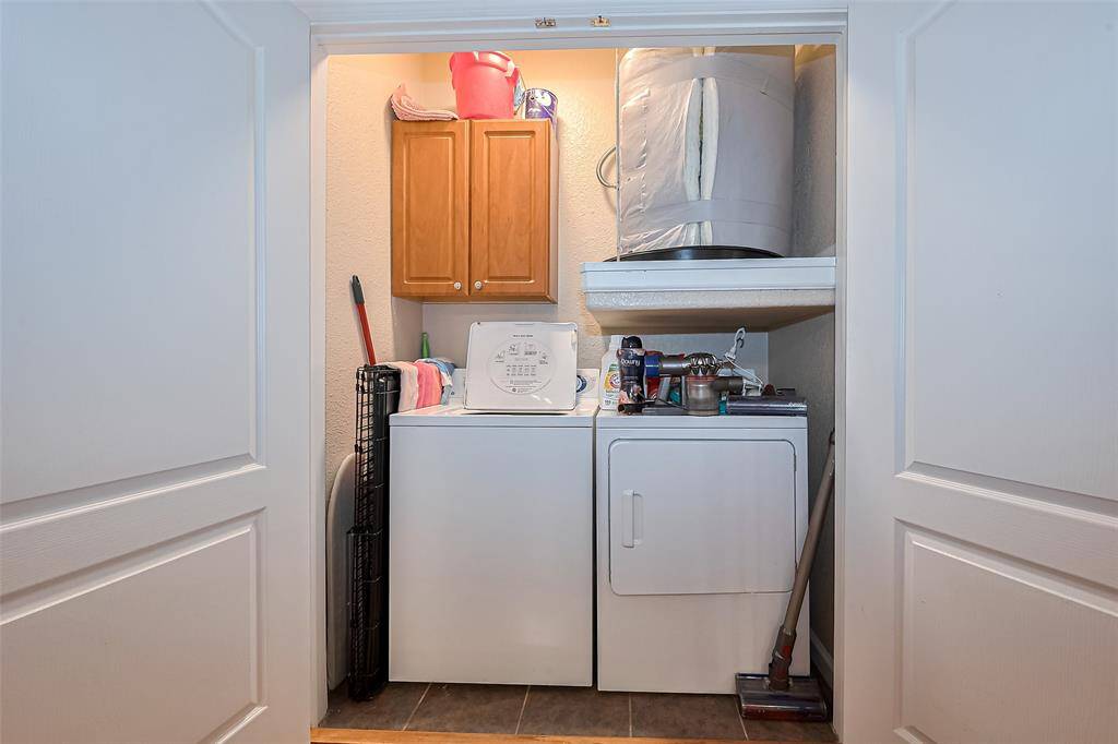 Compact yet efficient, the laundry room includes a cabinet above the washer and dryer—offering convenient storage without sacrificing space.