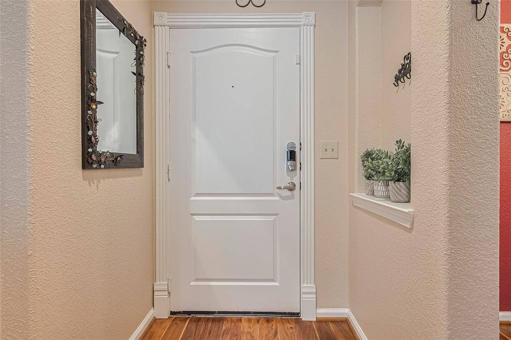 From inside, the entryway welcomes with a thoughtfully designed half-wall niche—perfect for art or décor—framing the line of sight straight into the heart of the home.