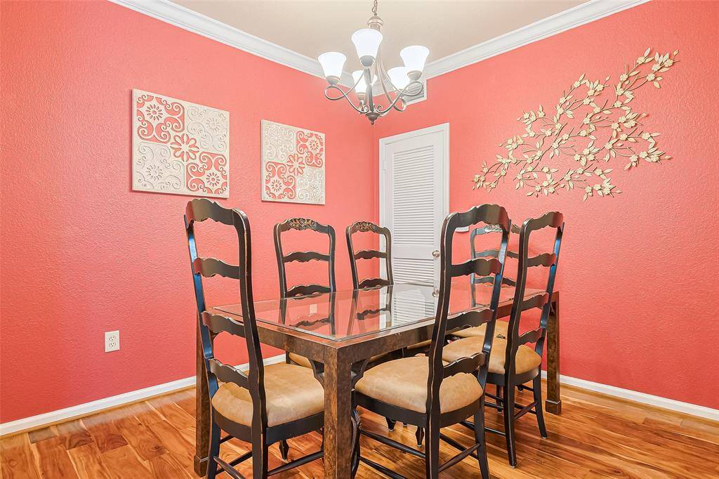 The dining space pops with vibrant walls and a touch of elegance from the stylish chandelier. It’s positioned just across from the kitchen for effortless dining.