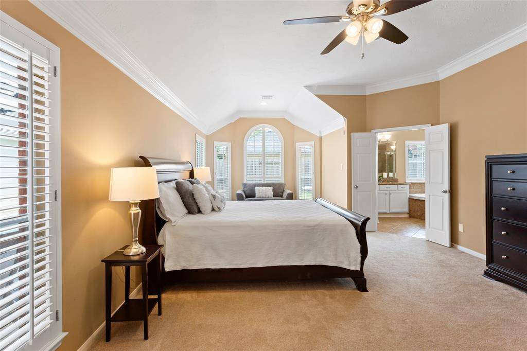 The oversized Primary Bedroom features a beautiful sitting area with bay windows and wooden plantation shutters. Views to the pool and backyard can be seen from any window in this room. An ensuite Primary Bathroom is connected by wooden French doors.
