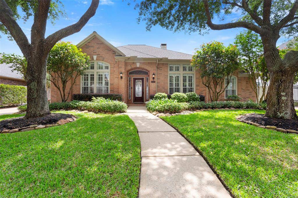 The front of the home features large windows and an elegant front door, offering great curb appeal on a serene cul-de-sac street.