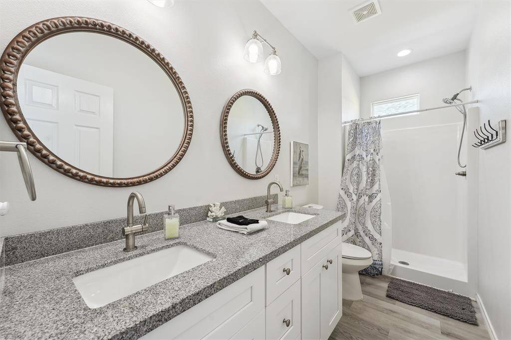 A bright and breezy guest bedroom with coastal flair, tray ceilings, and space to unwind after a day on the beach.
