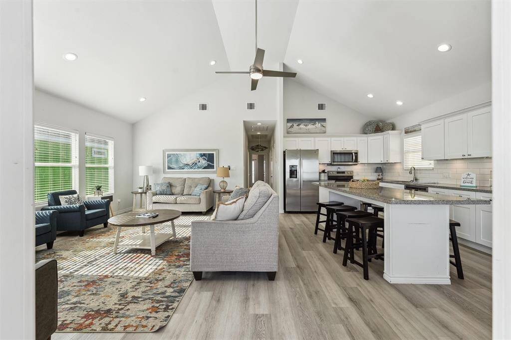 Bright and welcoming, this living room features vaulted ceilings and oversized windows that flood the space with natural light.