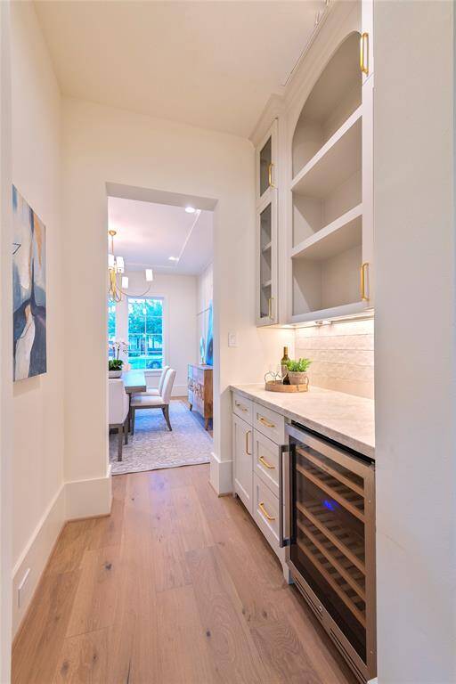 The butlers pantry connects the formal dining with the oversized kitchen.  the butlers pantry features wine storage, Taj Mahal quartzite countertops and zellige tiles.