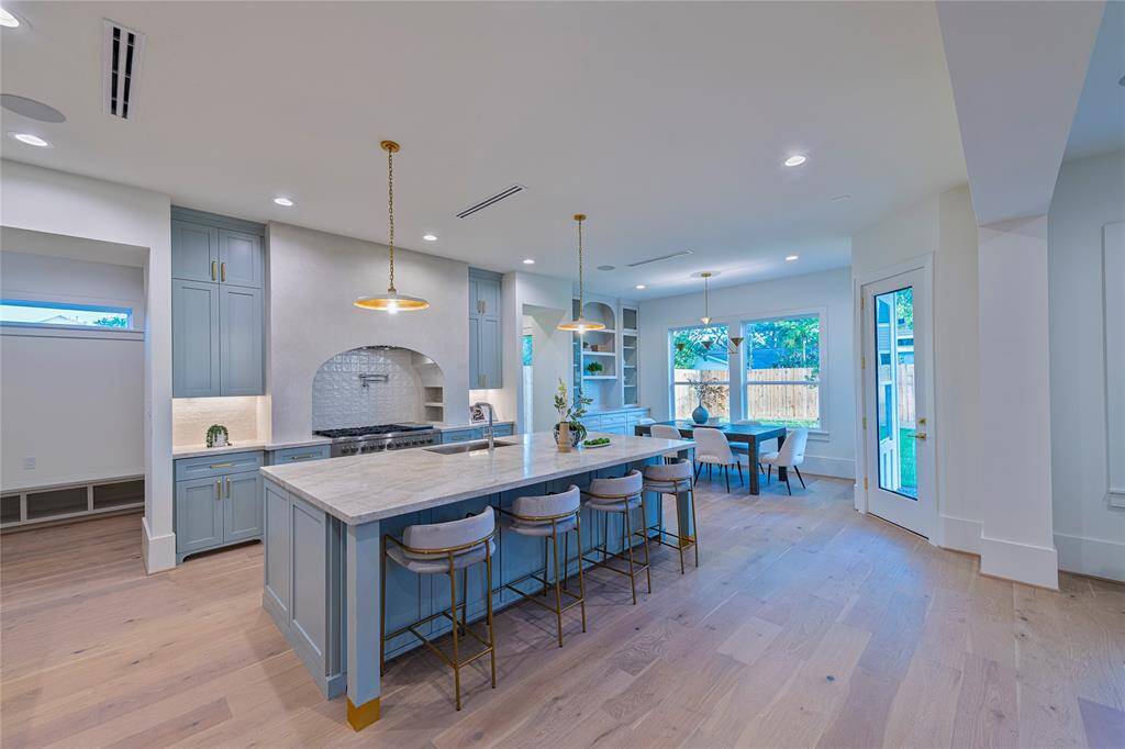 The island is accented with brass legs and visual comfort pendant lights.