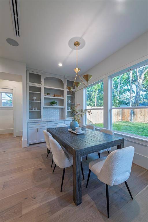 Eat in breakfast area is accented with designer lighting, oversized window and a beautiful buffet and display cabinet.