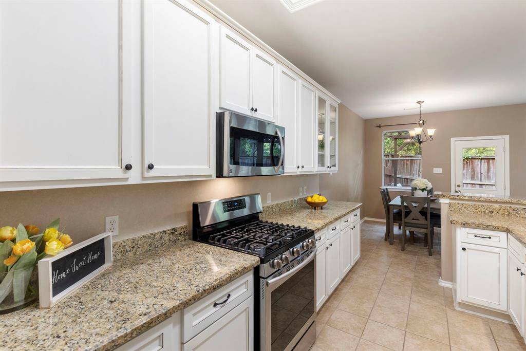 Bright white cabinetry and beautiful granite countertops give this kitchen a cheerful, welcoming feel.