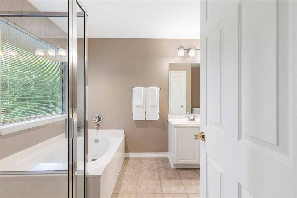 The primary bathroom features a large soaking tub, separate shower, and dual sinks—providing both relaxation and convenience.