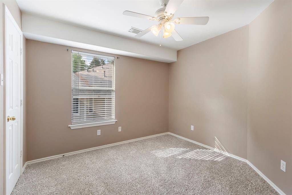 First secondary bedroom upstairs, offering a cozy space with plenty of natural light and a generously sized closet.