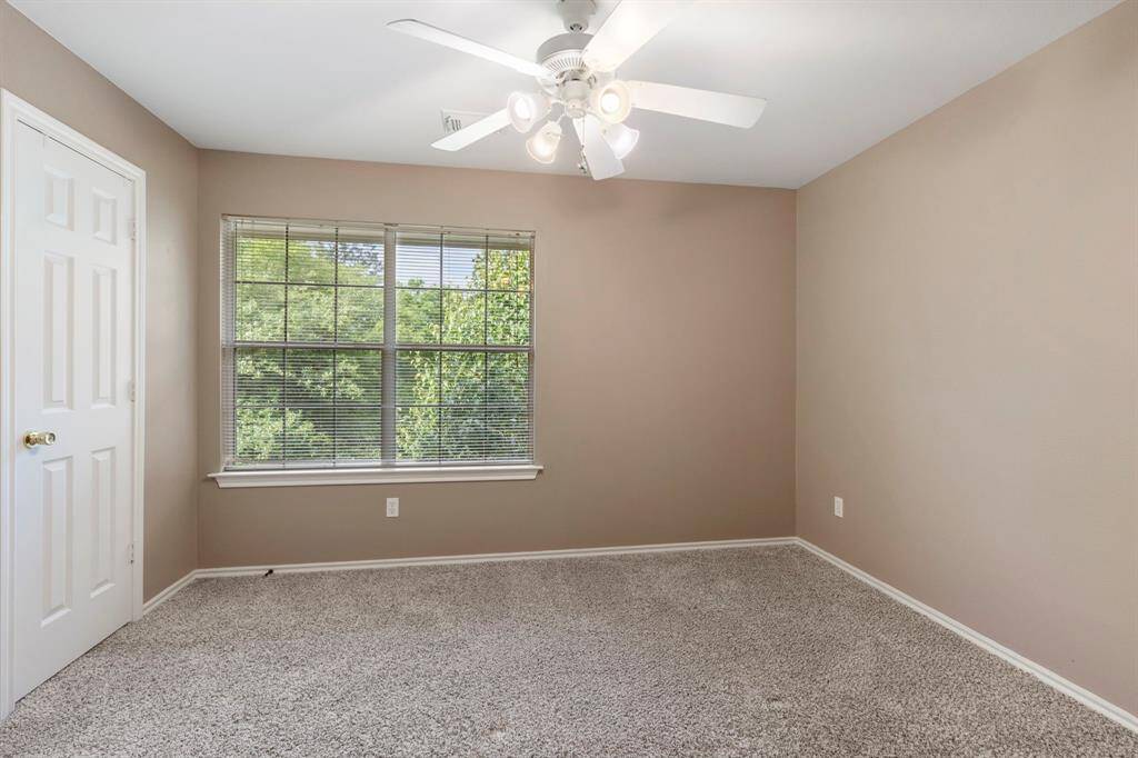 The second upstairs guest bedroom offers a lovely view of the outdoors and features a generously sized closet—perfect for guests or a home office.