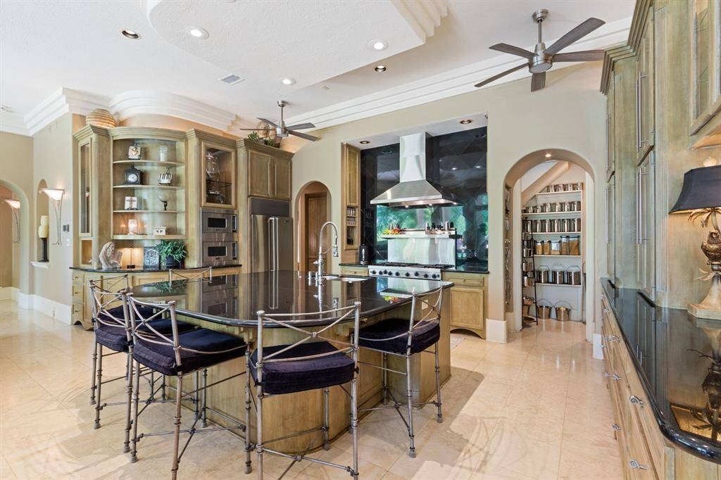 This amazing kitchens offers a Viking Range with 6 burners, a grill, and double ovens. A spacious center island with seating for six with Costco storage. The custom Viking Professional vent hood has a roof mounted motor. What a dream for the cook in the family!